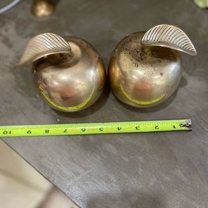Brass apple paper weights X2. Small dent on bottom of right apple. Shown in pic
